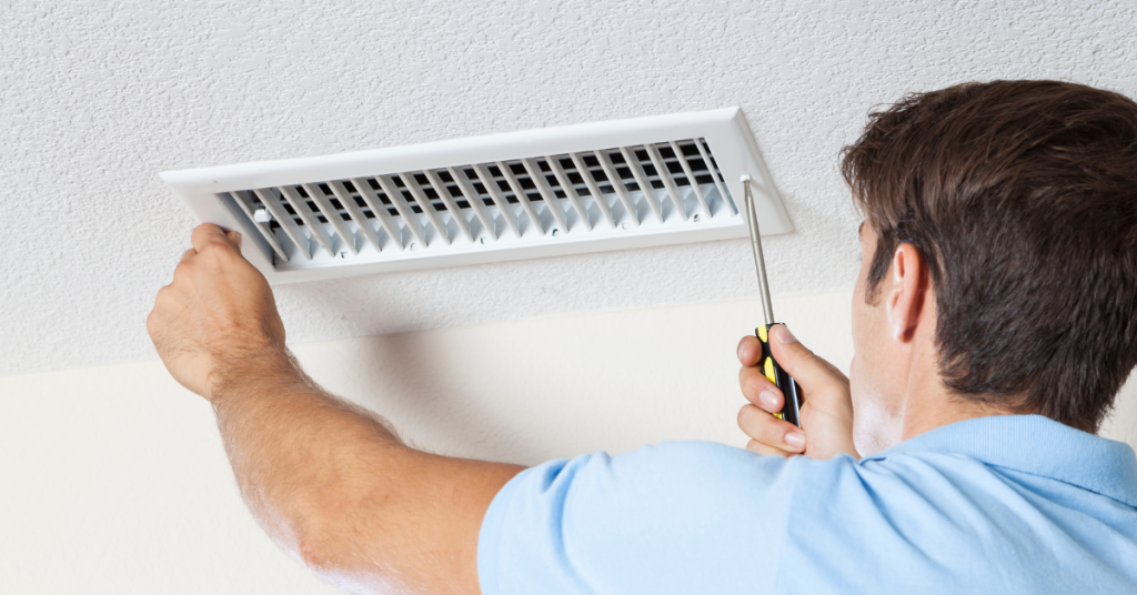 Image of a North Bay Heating and Cooling worker performing a repair in a home.